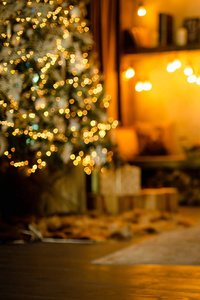 家庭背景。 带礼物的壁炉和圣诞树附近的阅读角落。 模糊的。
