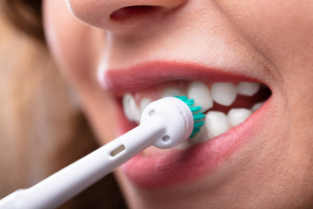 s Hand Brushing Teeth With Electric Toothbrush