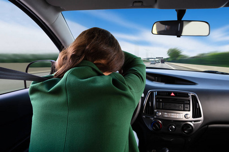 一个年轻女子乘汽车睡觉的后景