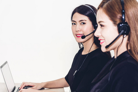 美丽的女商人客户支持服务,在呼叫中心使用耳机和电脑照片