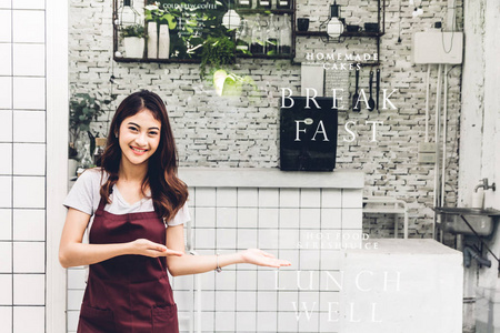 糕点叉女店主微笑着站在咖啡馆或咖啡店外交叉双臂的肖像.