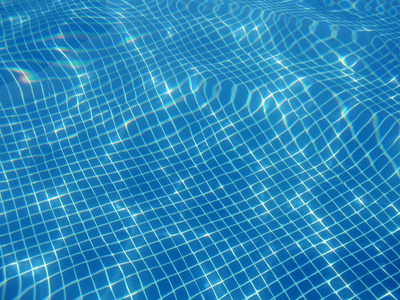 游泳池上的水反射。 水下摄影。 夏天。 水平水平