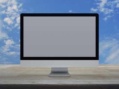 桌面现代电脑显示器，灰色宽屏幕，木制桌子，蓝天，白云