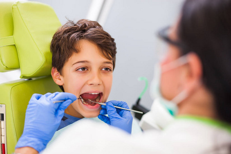 牙医正在检查一个男孩的牙齿。