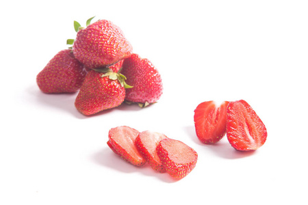 甜草莓，一半和整个浆果。 白色背景下分离的新鲜生红浆果