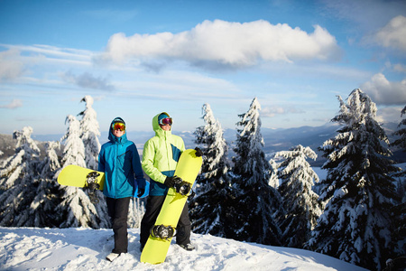 两个滑雪者在滑雪场摆姿势。骑手们的朋友们带着他们的滑雪板穿过森林, 在全国各地自由落体, 并穿着反光护目镜, 五颜六色的时尚服装