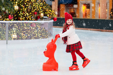 孩子们在冬季公园溜冰场滑冰. 孩子们在圣诞集市上滑冰.