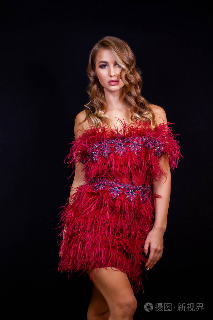 漂亮的金发女郎穿着红色性感的连衣裙. 健康的长卷发.