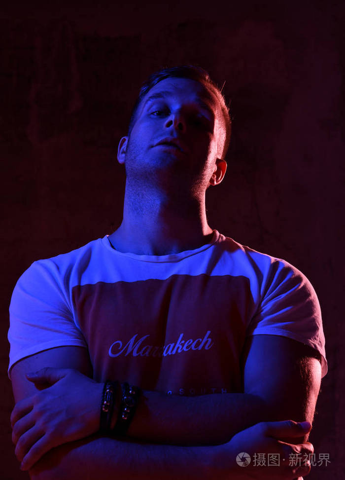 霓虹灯轻的性感男人肌肉发达的身体和白色 t恤抬头看