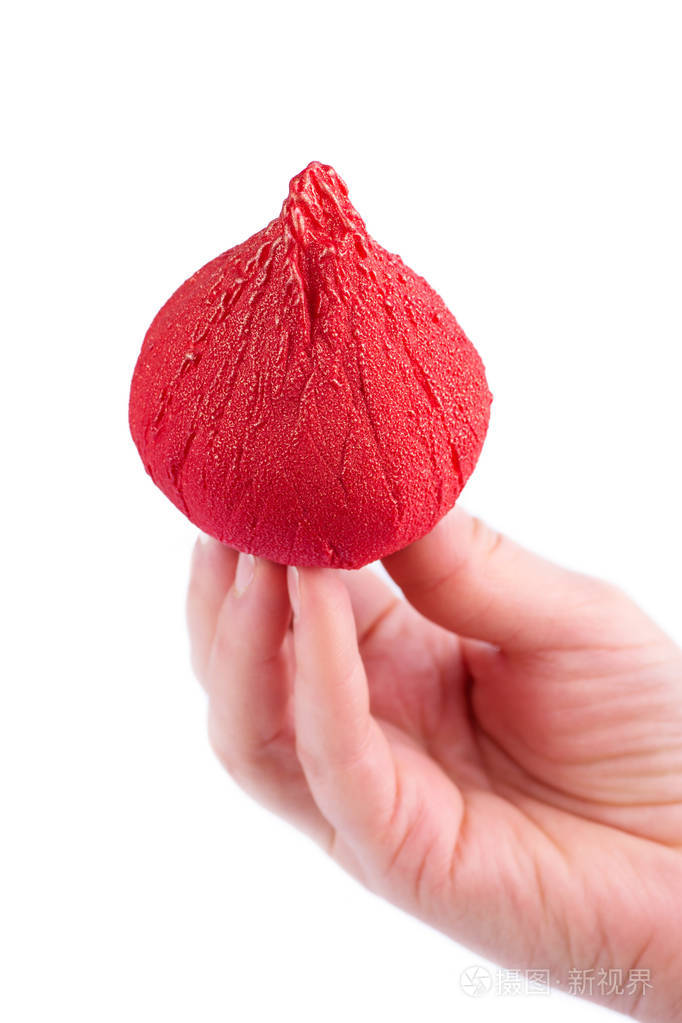 人手拿着白色背景的红色釉糖照片-正版商用图片14tj49-摄图新视界