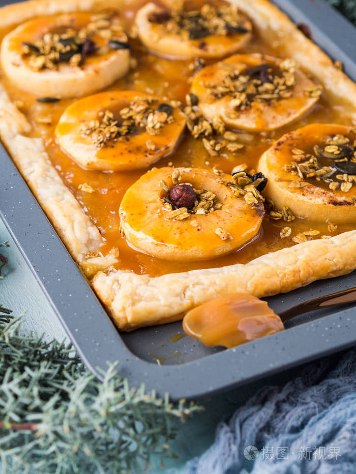 苹果派在烤盘上与焦糖和坚果