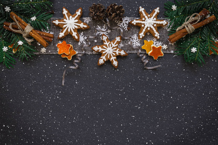 框架与冷杉树枝, 饼干和圣诞装饰在黑暗的石头背景。顶视图