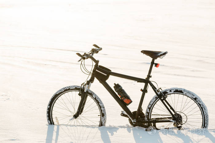 冬季自行车赛市中心雪地上的黑色自行车运动在一年中的任何时候的概念
