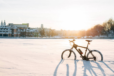 冬季自行车赛。 市中心雪地上的黑色自行车。 运动在一年中的任何时候的概念。
