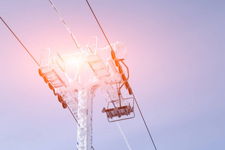 滑雪缆车绳索在蓝天日出日落的背景上有柱子。 铭文的地方，共空间。 阿尔卑斯山度假胜地的概念佐治亚索契物质角