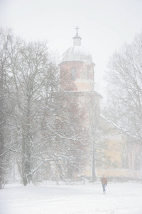 下雪的教堂。 拉脱维亚的冬天。 教堂被雪覆盖。 冬天的景象，白雪覆盖的教堂和树木