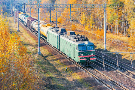 长途货运列车在秋日到达车站。