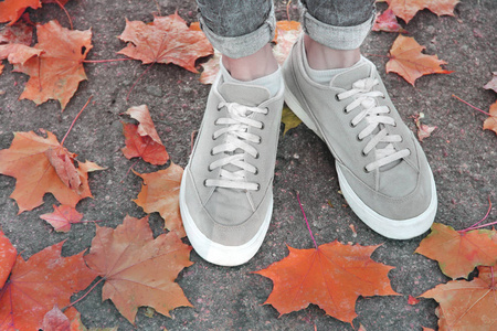 脚踩在秋叶的背景上