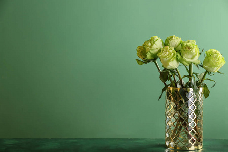 花瓶，桌上放着漂亮的绿色玫瑰花束，背景是彩色的