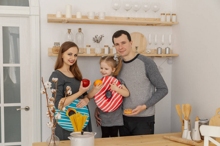 有趣和美丽的家庭三在厨房里玩的乐趣