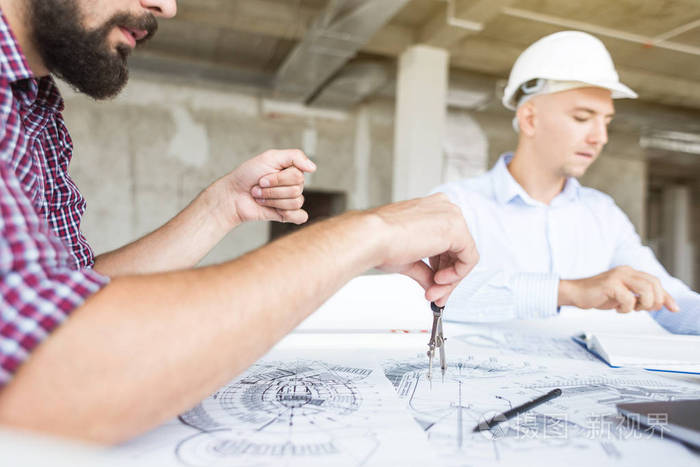 戴头盔在办公桌前工作的男性工程师,建筑师.