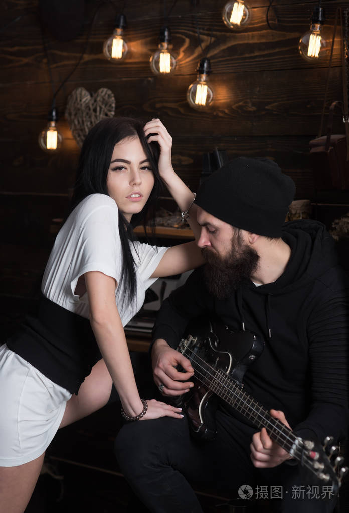 摇滚风格的情侣.有胡子的男人弹吉他性感的女人.