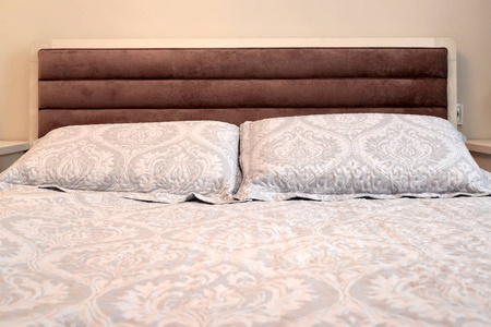 带枕头的双人床的床头板。 斯堪的纳维亚风格