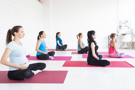 怀孕运动健身人和健康生活方式概念组快乐孕妇在白色背景健身房锻炼瑜伽和冥想莲花姿势