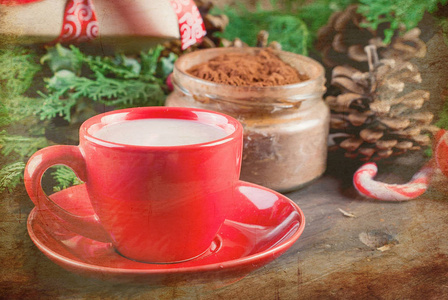 圣诞节和寒假自制的红杯热巧克力，一棵冷杉树枝，糖果棒和生姜饼干在木制背景上。 假日概念复制空间