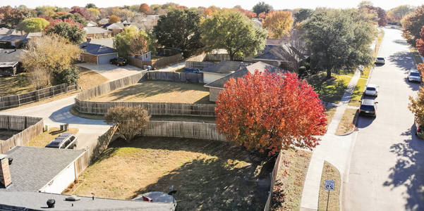 全景俯视美丽的社区在科佩尔德克萨斯美国秋季季节。 一排独栋的家庭住宅，附属的车库花园，环绕着蓝天下五颜六色的落叶