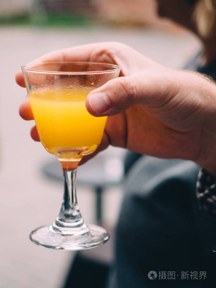 手里拿着玻璃杯里的鸡尾酒酒吧餐厅背景
