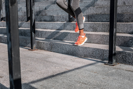 漂亮的年轻女子在锻炼时从楼梯上跑下来照片