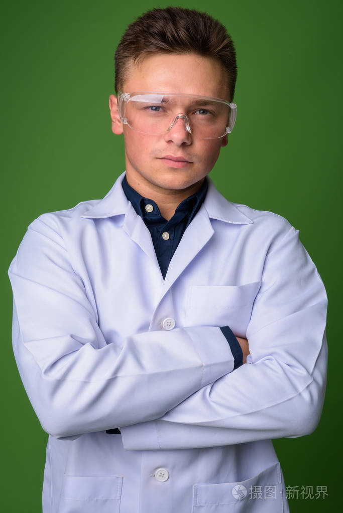 年轻英俊的男人医生戴防护眼镜对 gre