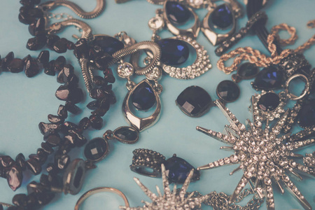 美丽珍贵的闪亮珠宝时尚迷人的珠宝套装, 项链, 耳环, 戒指, 链, 胸针珍珠和钻石在蓝色的背景。平面布局, 顶部视图, 复制位
