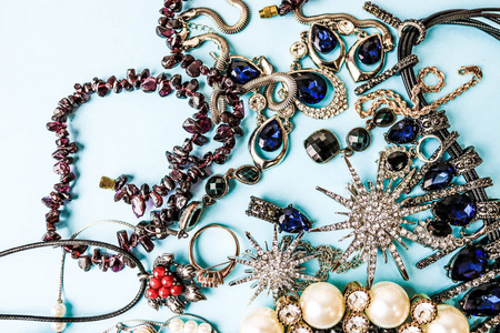 美丽珍贵的闪亮珠宝时尚迷人的珠宝套装, 项链, 耳环, 戒指, 链, 胸针珍珠和钻石在蓝色的背景。平面布局, 顶部视图, 复制位