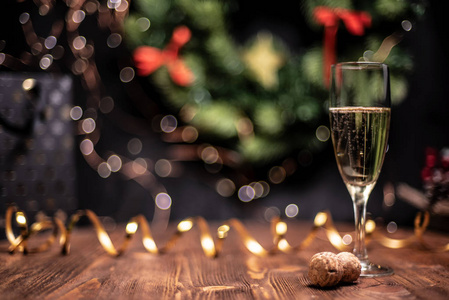 光滑的阴凉的圣诞节和新年装饰背景与圆形的Bokeh金丝带和一杯香槟和软木塞。
