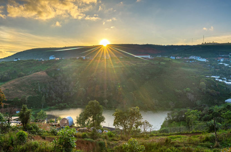黎明在高原上,天空五彩缤纷,太阳从地平线升起,照耀着小村庄,美丽的