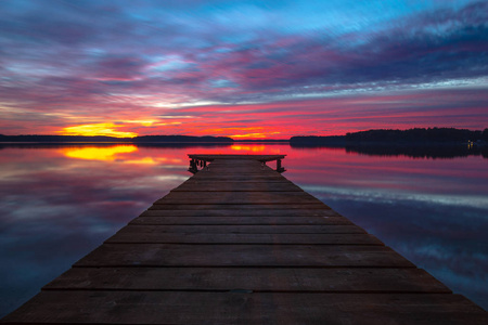 美丽的五颜六色的日落，湖里有一个木制码头
