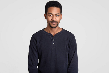 齐腰的肖像一个留着短卷发,小胡子的黑人男子的齐腰镜头,严肃地看着