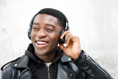 特写幸福的年轻黑人用耳机听音乐的画像