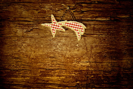 圣诞节背景的文字或照片，可爱的明星伯利恒，由织物制成，挂在一个旧的木墙上，空空间的信息或照片。 水平图像。