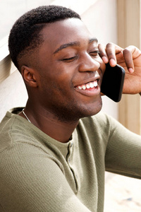 特写照片微笑的年轻非裔美国人在户外打电话
