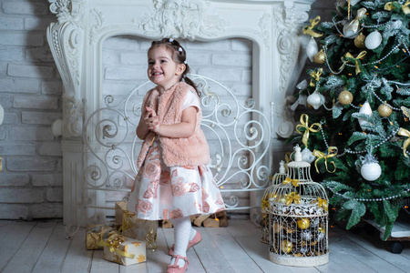 快乐快乐的小女孩在圣诞树附近玩得很开心。