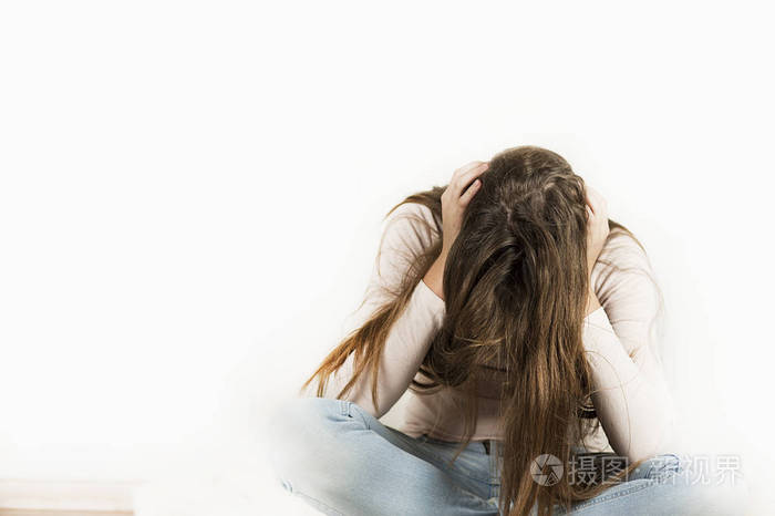 一个非常悲伤愤怒的情感女孩正坐在一个孤立的背景上