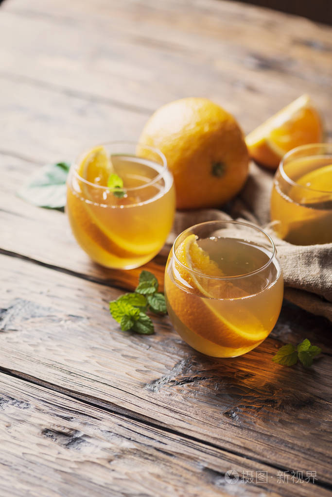 木桌上放着橘子和薄荷的冷茶