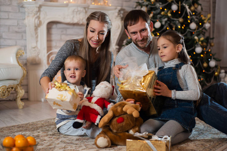 圣诞照片的幸福家庭与礼品盒背景装饰圣诞树。 家人庆祝新年