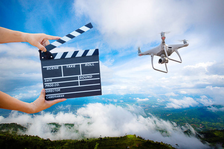 男人手拿着电影clapper.电影导演的概念。 无人机直升机飞行图像捕捉运动在采访或广播婚礼捕捉感觉手握电影板岩与无人机直升机。