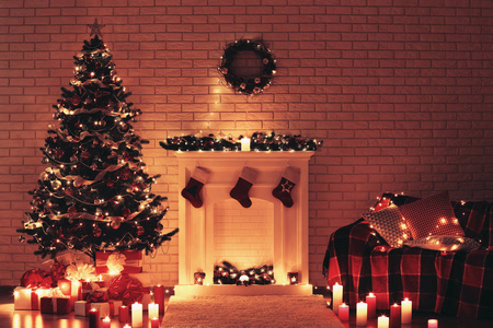 圣诞树附近的白色壁炉和砖墙背景的沙发