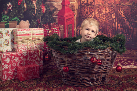 可爱的孩子在篮子里，靠近圣诞树