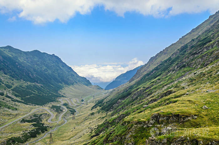 法加拉斯山上的transfagarasan路，喀尔巴阡山上有绿草，云中有山峰。